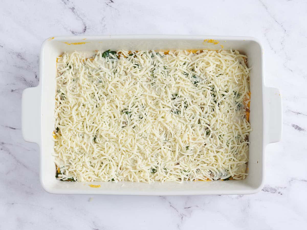 Une lasagne maison à la courge musquée garnie de fromage râpé.