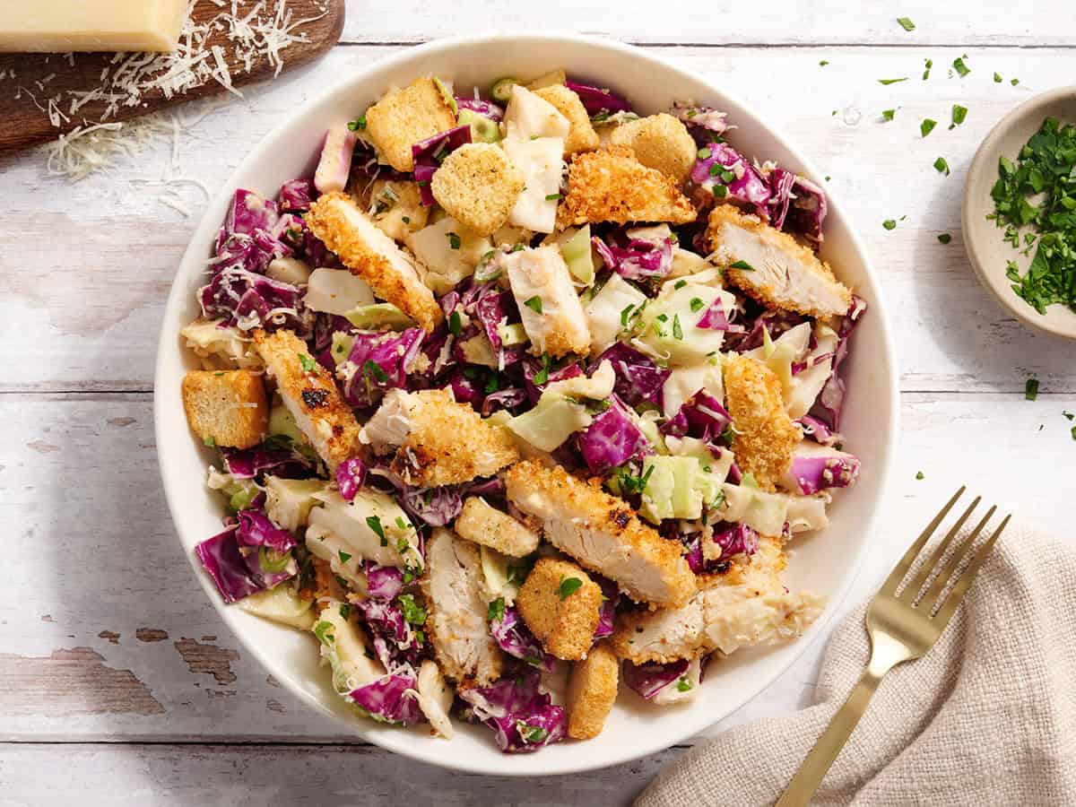 Vue aérienne d'une salade de poulet César au chou dans un bol.