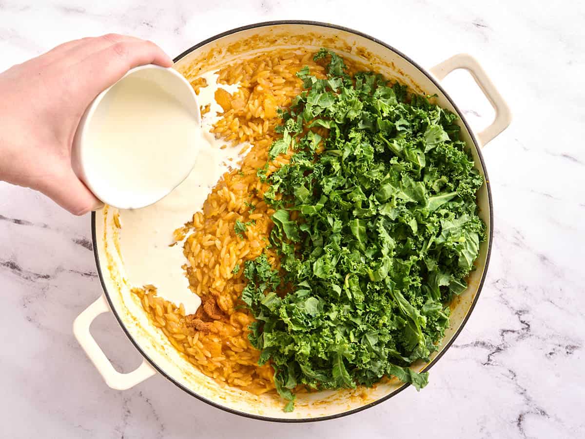 Orzo de courge musquée dans une poêle avec du chou frisé frais et de la crème.
