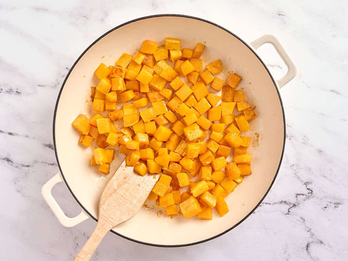 Coupez la courge musquée en dés dans une poêle avec une spatule en bois.