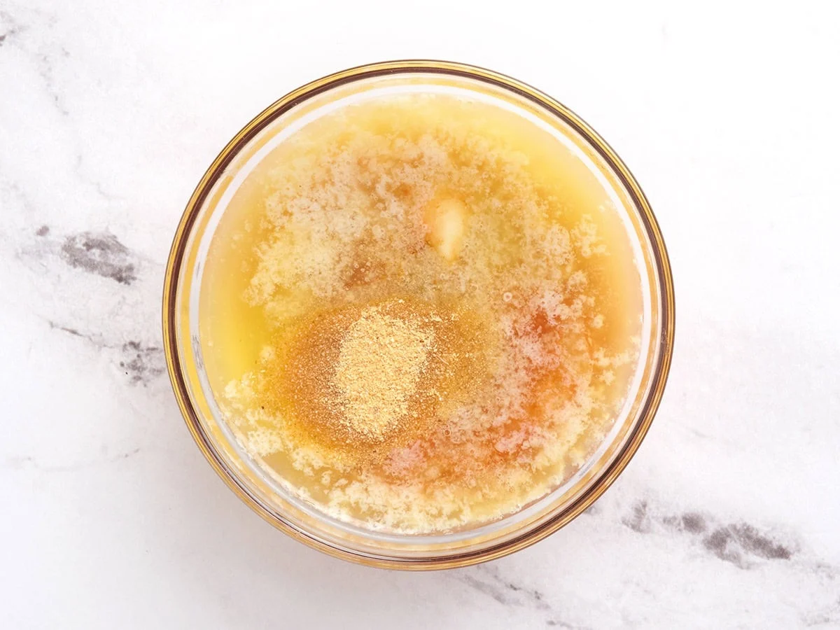 Beurre fondu, sauce piquante, sauce Worcestershire et poudre d'ail dans un bol.